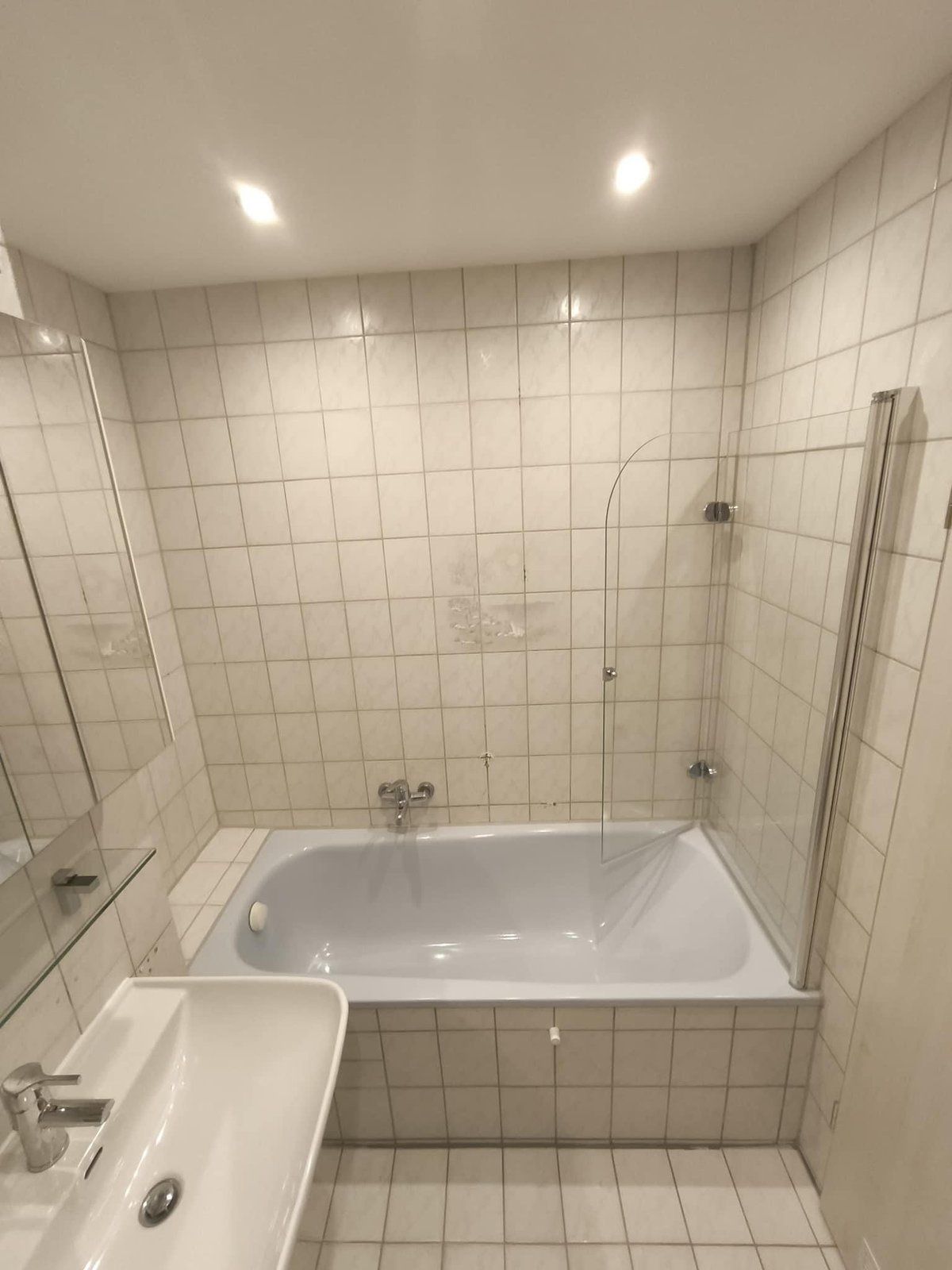 Vorher: gefliestes Bad mit Badewanne und Faltwand